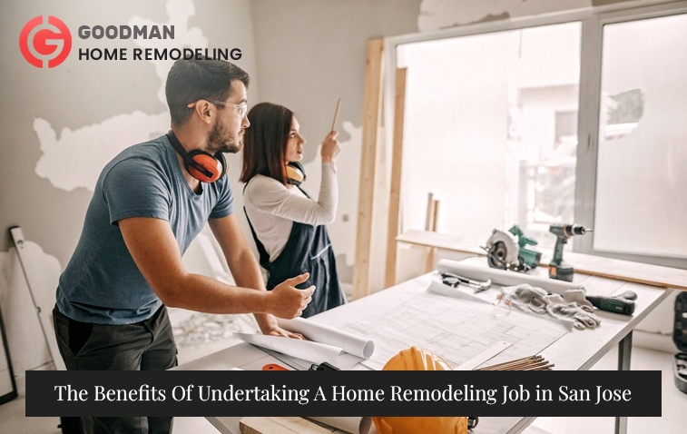 Designer and homeowner discussing plans in an underconstruction home with documents on the table.